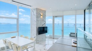 A modern interior with a large window offering a view of a bridge over water.
