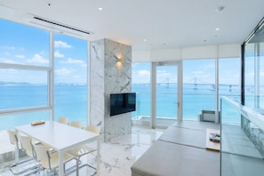 A modern interior with a large window offering a view of a bridge over water.
