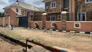 A residential building with a gated entrance, multiple windows, and a brick facade. - Plus 234 Hotels and Suites (Ibadan)