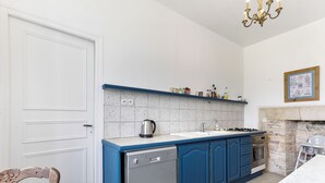 Cozinha com lava-louças, fogão e bancada azul.