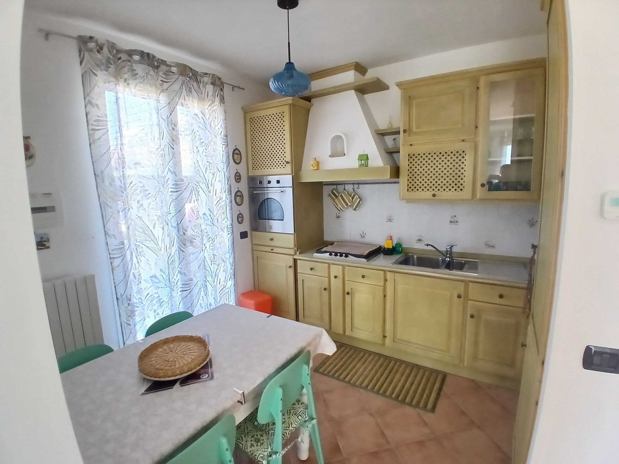 Een keuken met een eettafel, een kookplaat en een gootsteen.