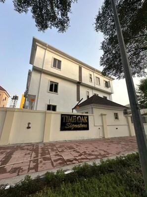 Um edifício de vários andares com uma placa que diz 'TIMI OAK Signature'.