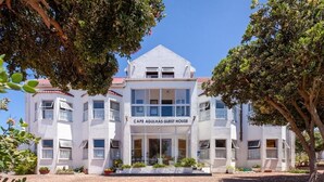 Un edificio a più piani con un'insegna che recita 'CAPE AGULHAS GUEST HOUSE'.