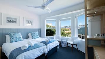 Habitación de hotel con cama, dos sillas, escritorio y vista al exterior.