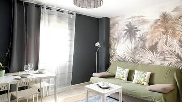 Ein modernes Wohnzimmer mit Sofa, Couchtisch und Essbereich.