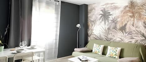 Una sala moderna con sofá, mesa de centro y comedor.