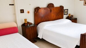 A room with two beds, a wooden headboard, a nightstand, and a wall with a picture. - Historic Stay Near the Sassi of Matera (Matera)