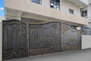 A gated entrance with ornate metalwork and a balcony above. - Super Collection O Danapur (Danapur)