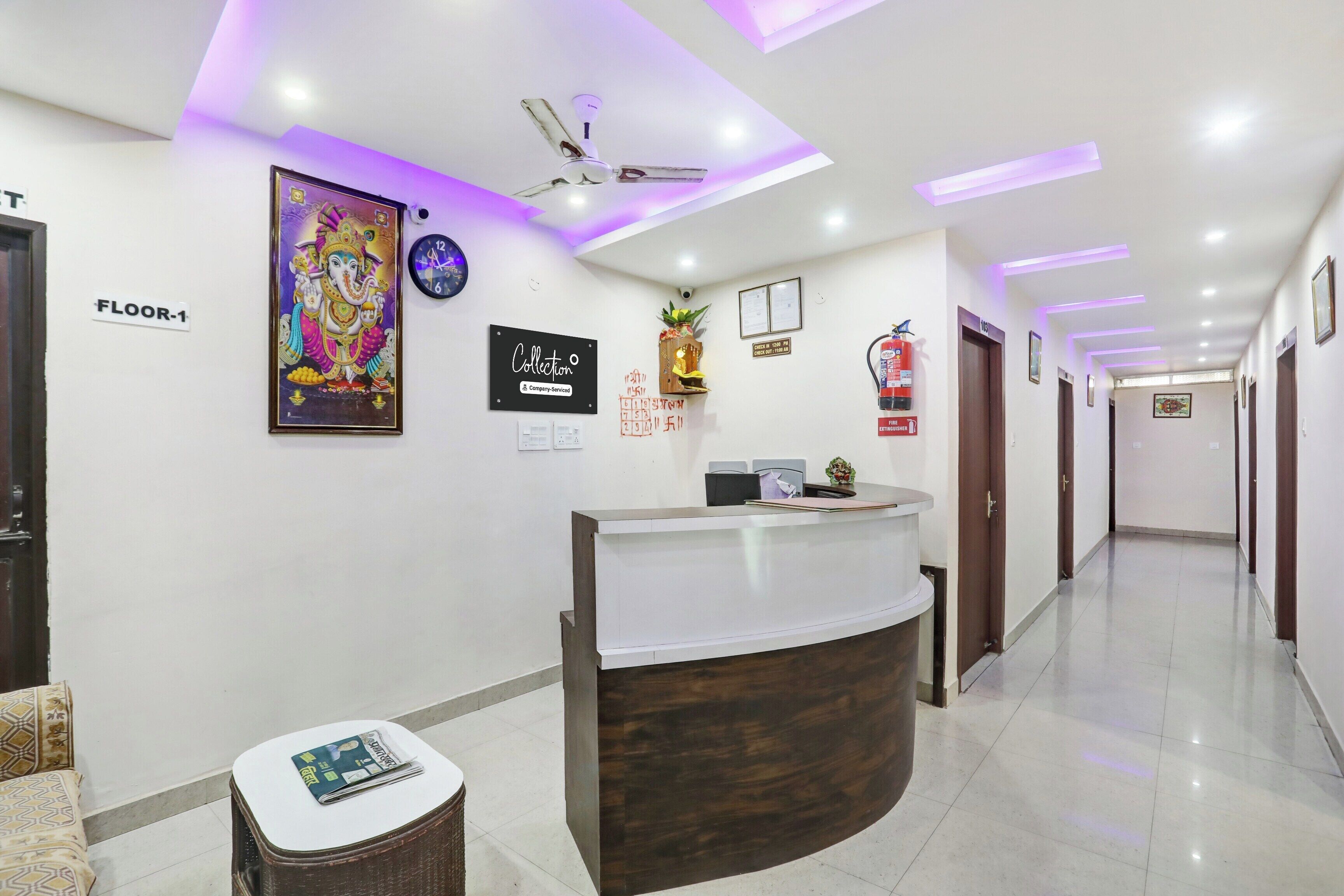 A hotel reception area with a reception desk, a clock, a fire extinguisher, and a sign indicating the floor number.