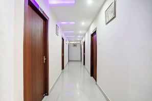 A hallway with wooden doors, numbered 103 and 108, and a framed picture on the wall. - Super Collection O Danapur (Danapur)