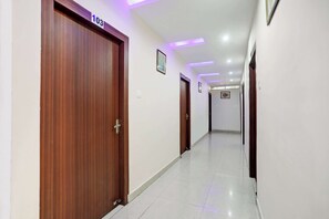 Un pasillo con puertas de madera, numeradas 103, y un corredor que lleva a otra habitación.