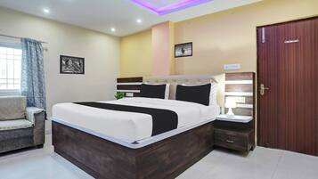 Un dormitorio con cama, mesitas de noche, armario y ventana con cortinas.