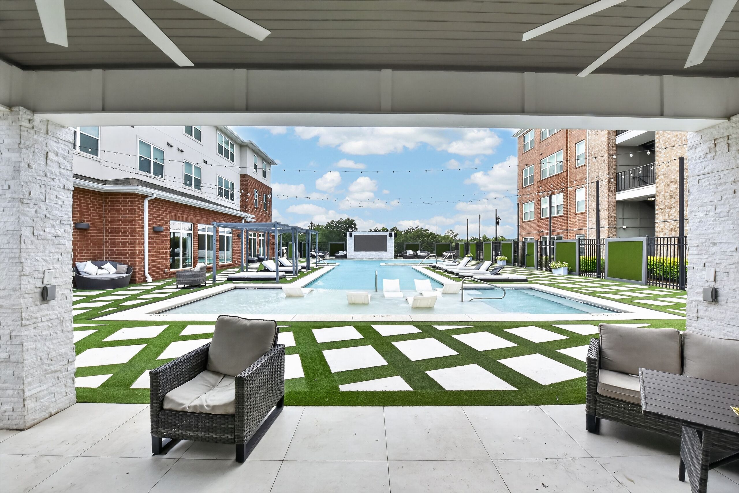 A pool area with lounge chairs and a clear view of the surrounding buildings.