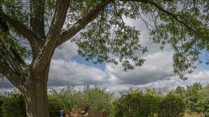 Un letrero de madera con la leyenda 'Oak Glen', rodeado de árboles y follaje.