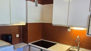 A compact kitchen with a built-in stove, a sink, and a coffee maker. - Avoriazien style apartment with view - 6 guests (Avoriaz)