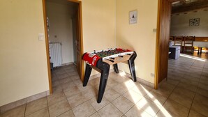 A room with a foosball table, a radiator, and a door leading to another room. - Countryside house in Berry, near Loire Castles (Clion)