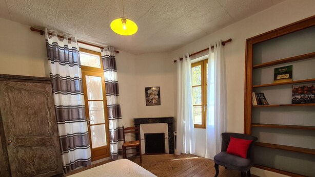 A room with a bed, a fireplace, a bookshelf, and a chair. - Countryside house in Berry, near Loire Castles (Clion)