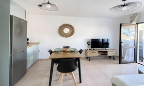 A modern kitchen with a dining area, a television, and a large mirror on the wall. - Vacation Apartment 'B-rent Oasis Dunas Sunset Gael' with Shared Pool, Private Terrace and Wi-Fi (Corralejo)