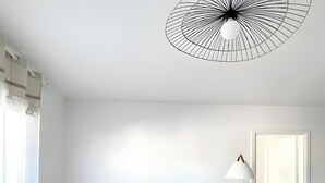 Un salon moderne avec un canapé gris, une table basse ronde en bois et un lampadaire.