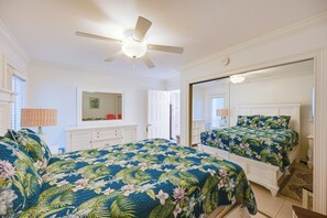 A bedroom with two beds, a ceiling fan, a large mirror, and a dresser. - Walk to Beach! Old Naples Condo w/ Pool Access (Naples)