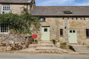 A stone building with a green door, a small window, and a sign that reads 'Welcome'. - Dashel Cottage at Dockwell Farm (Newton Abbot)