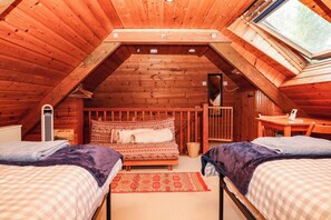 A cozy attic bedroom with two beds, a desk, and a window. - Dashel Cottage at Dockwell Farm (Newton Abbot)