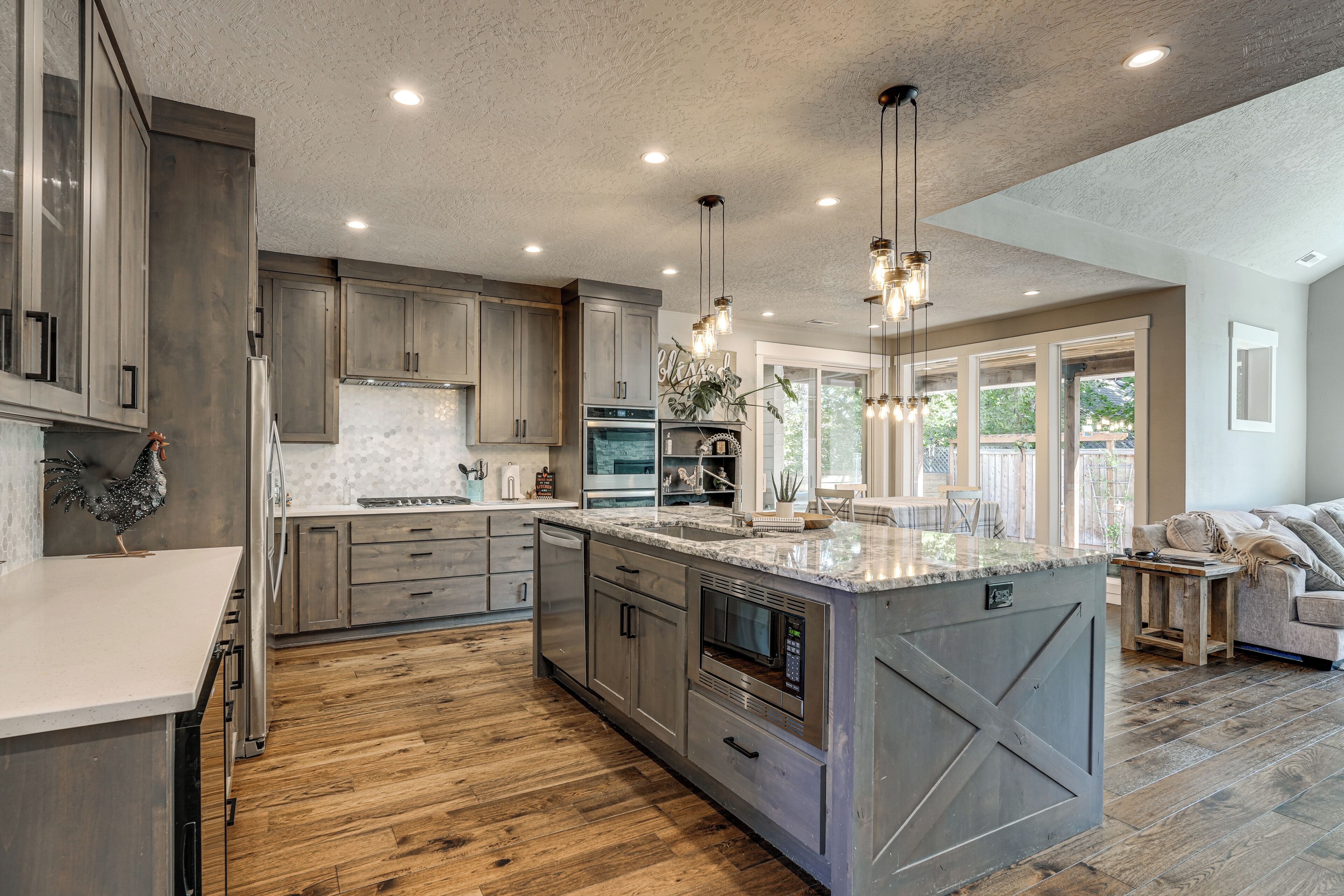 A spacious kitchen with a large island, wooden cabinets, and modern appliances.