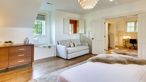 A bedroom with a large bed, a dresser, a sofa, and a chandelier. - Views, Hot Tub & Fire Pit! Luxe Blue Ridge Retreat (Blowing Rock)