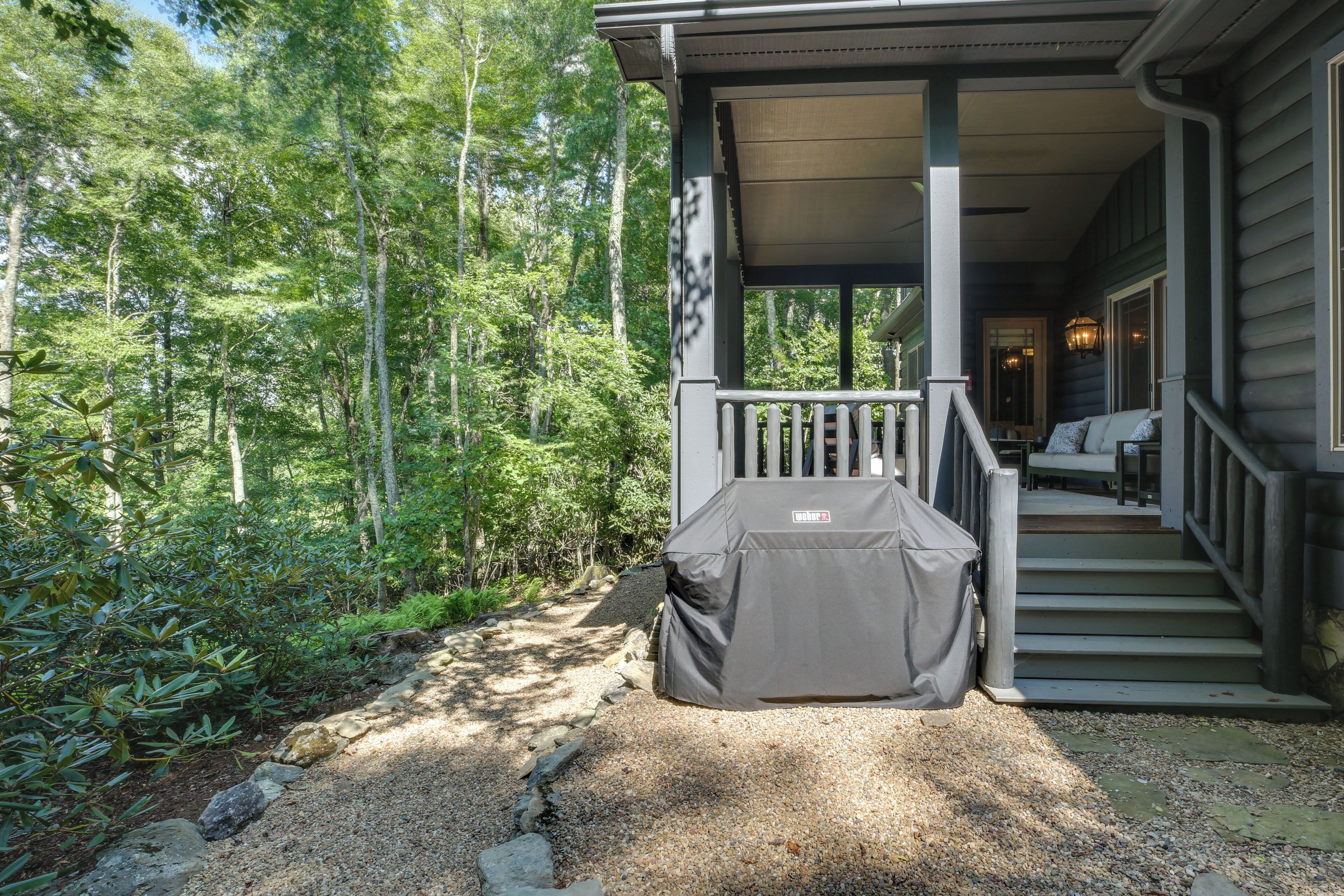 A covered outdoor grill area with a staircase leading to a porch.