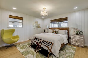 Une chambre à coucher comprenant un lit, une chaise, une table de chevet et une petite table.