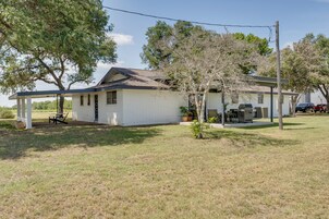 A single-story house with a covered porch, a small attached garage, and a lawn.