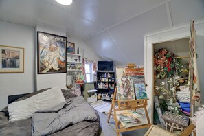 A cozy room with a bed, a painting on the wall, and a bookshelf. - Walk to Main St Stroudsburg! Historic Dtwn Home (Stroudsburg)