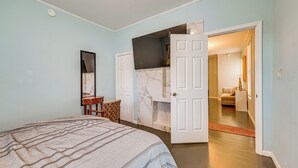 Un dormitorio con cama, cómoda, espejo y puerta que da a otra habitación.