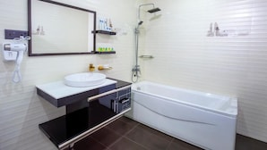Un baño con un lavamanos blanco, un espejo, una ducha y una bañera.