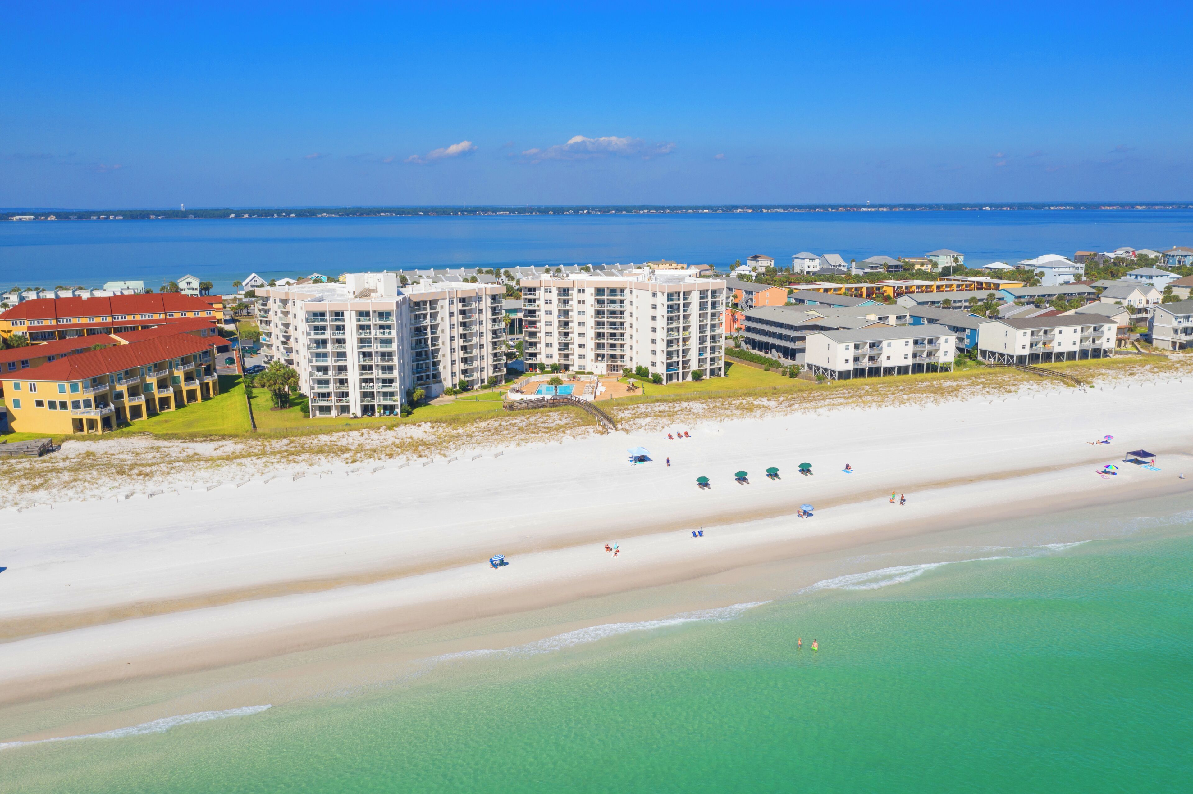 Ein Küstenhotel mit mehreren Gebäuden, einem Strand und freiem Blick auf den Ozean.