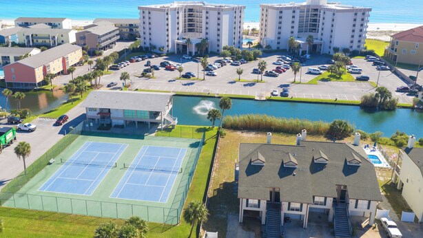 Un hôtel à plusieurs étages doté d’un court de tennis et d’un parking.