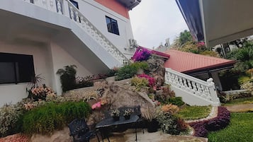 A multi-level outdoor area with a staircase, potted plants, and a seating area.