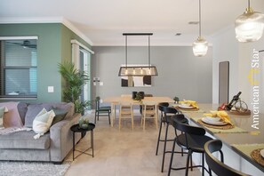 Un salon moderne avec un canapé, une table à manger et des chaises.