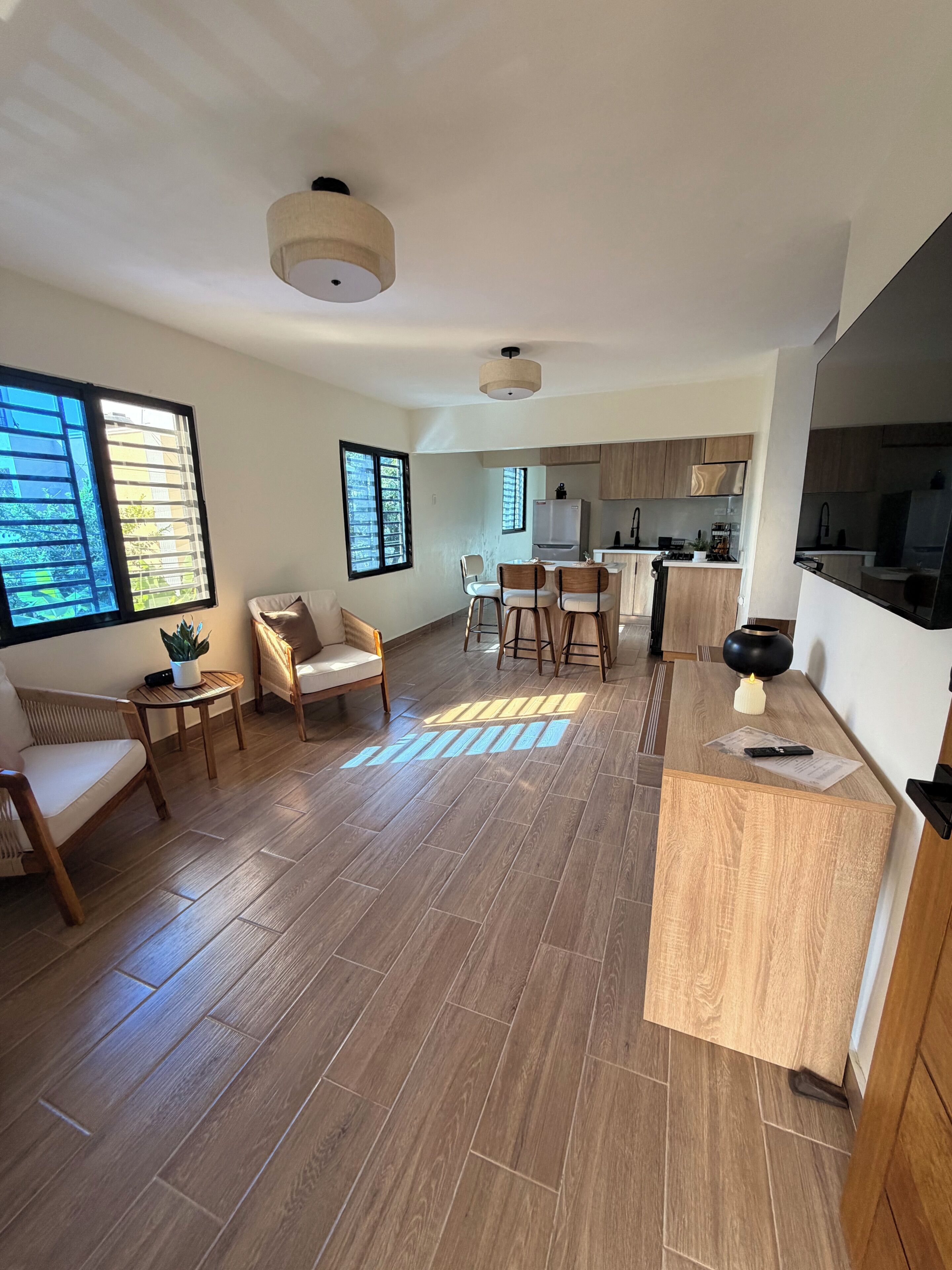 Een ruime woonkamer met keuken, eettafel en zithoek.