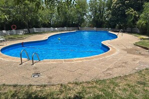 A swimming pool with a curved edge, surrounded by a white fence, and a grassy area in the foreground. - Mountain & Pool Retreat - Pitres Campground (Pitres)