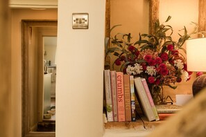 A bookshelf with books and a floral arrangement. - Boutique Cotswolds Cottage near Soho Farmhouse (Duns Tew)