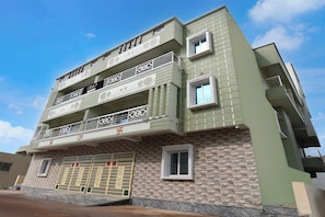 Un edificio de varios pisos con balcones y un garaje.