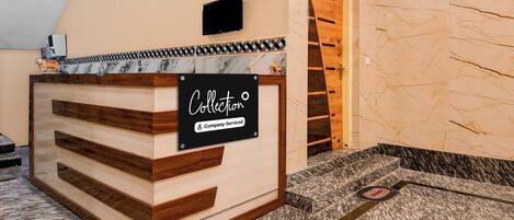 A reception desk with a sign indicating it is company-serviced.