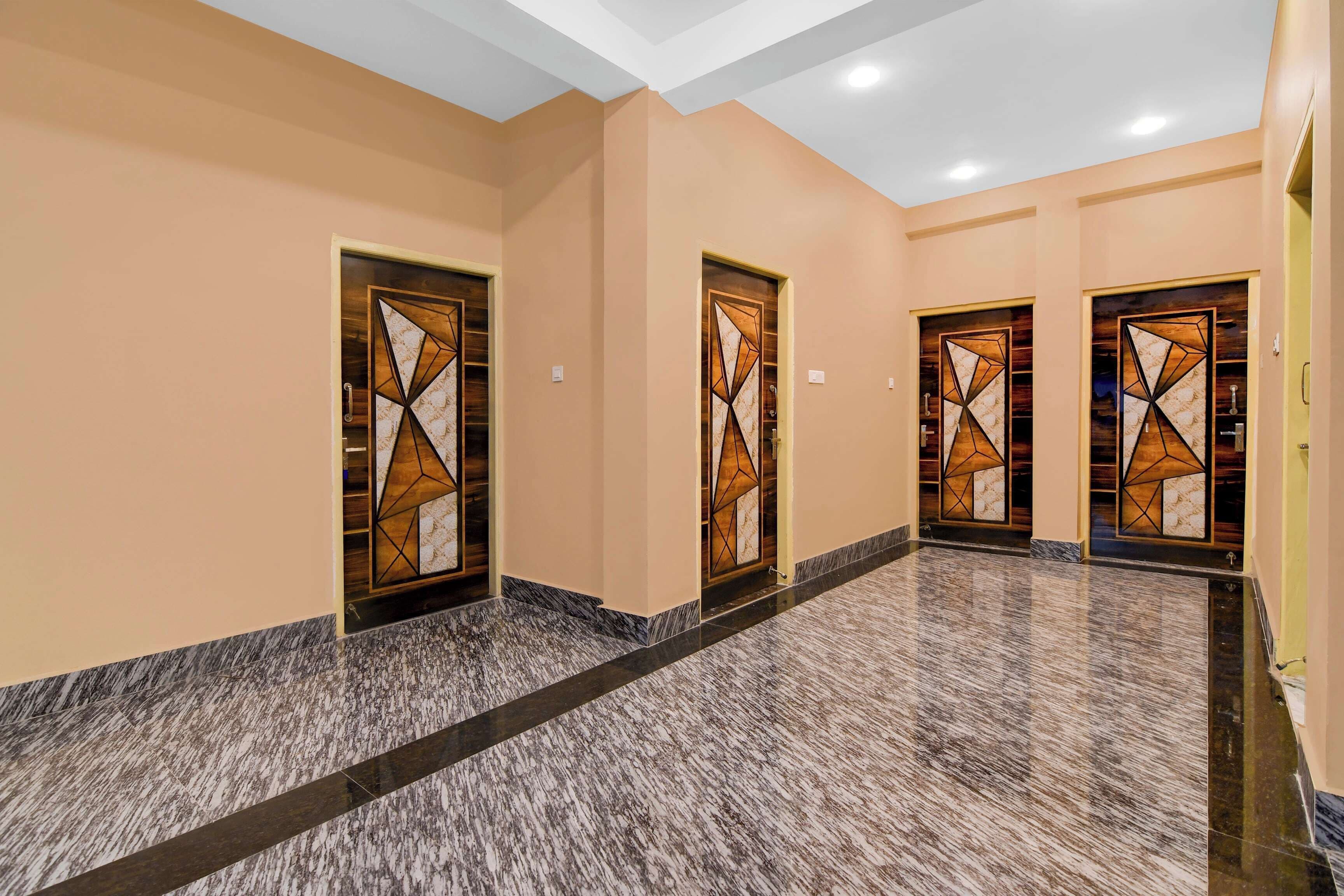 A hallway with three doors, each with a geometric pattern, leading to rooms. The floor is tiled with a marble-like pattern.