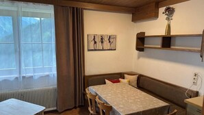 Ein Essbereich mit Tisch, Stühlen, einer Bank und einer Heizung.