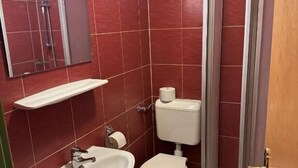 Ein Badezimmer mit Waschbecken, Toilette und Dusche.