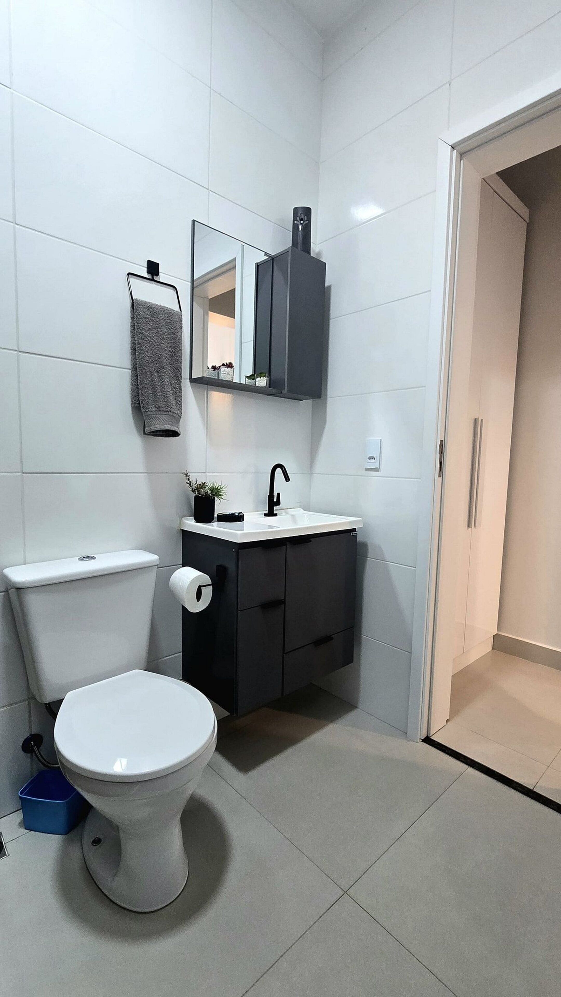 Ein modernes Badezimmer mit Toilette, Waschbecken und Schrank.