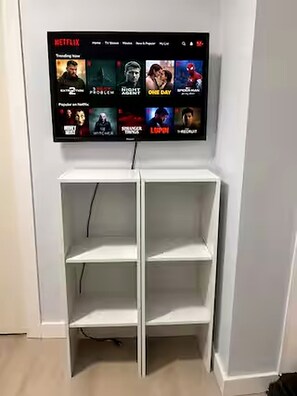 A wall-mounted TV displaying a selection of movies and TV shows. - Cozy European Studio Walk to Caesars Free Parking (Windsor)
