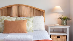 A bed with a wooden headboard, multiple pillows, a bedside table with a lamp, and a small plant. - Periwinkle - perfect base for a beachside getaway with family and pets (Culburra Beach)
