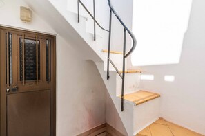 Eine Treppe mit Metallgeländer und einer Holzplattform.